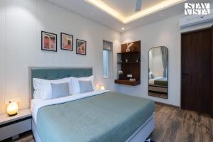 Un dormitorio con una cama grande y un espejo. en StayVista at Oriana Palms with Wifi and Pool, en Igatpuri