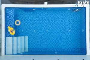 a blue swimming pool with a yellow toy in it at StayVista at Oriana Palms with Wifi and Pool in Igatpuri