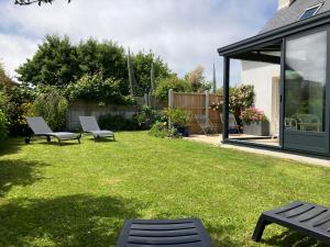a yard with two chairs and a house at Maison à 200m des plages de Brignogan - Holiday Home-Fereinhaus in Brignogan-Plages