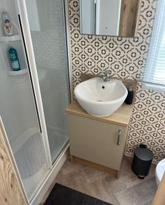 a bathroom with a sink and a shower at 75 Orchard Mount, 3 bed luxury caravan Skirlington- sleeps 6 in Hornsea