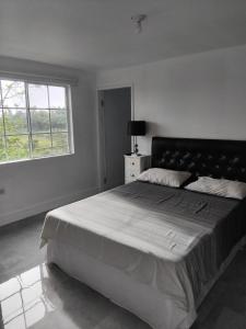 a bedroom with a large bed and a window at Clarke Place in Mandeville