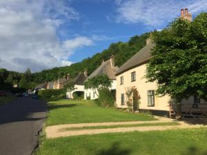 eine Reihe von Cottages am Straßenrand in der Unterkunft Three Little Pigs Luxury Cottage in Milton Abbas