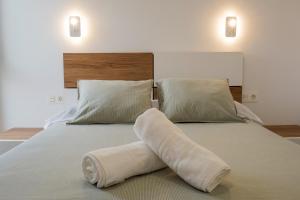 a bed with a towel on it with two pillows at Home2Book Coastal Calm Las Eras Patio Rooftop in Las Eras