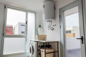 a laundry room with a washing machine and a window at Home2Book Coastal Calm Las Eras Patio Rooftop in Las Eras +110 photos