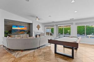 a living room with a pool table and a couch at The Deserts Best Kept Secret by Navigate Stays in Desert Groves Mobile Home Park