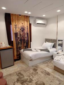 een slaapkamer met twee bedden en een schilderij aan de muur bij Paradise Pyramids View INN in Caïro +93 foto's