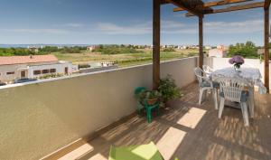 a patio with a table and chairs on a balcony at Apartment Tia - by TA Leut Agency in Privlaka