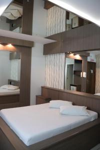 a bedroom with a bed and a large mirror at Motel Chevalier - Athos Hospedagem in Lages