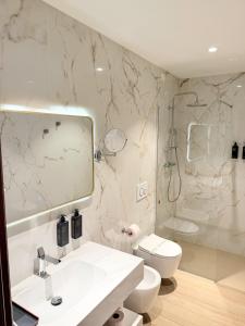 a bathroom with a sink and a toilet and a shower at Lh HOTELS in Milan +20 photos