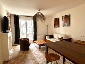 a living room with a table and a couch at Appartement duplex centre-ville entièrement rénové in Mortagne-au-Perche