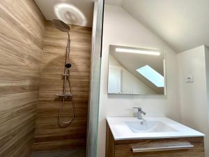 a bathroom with a sink and a shower with a mirror at Appartement duplex centre-ville entièrement rénové in Mortagne-au-Perche