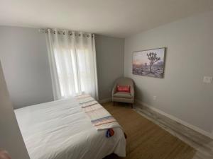 une chambre avec un lit, une chaise et une fenêtre dans l'établissement 4th Street, à Bend