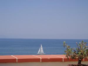 a sail boat in the ocean with a boat in the water at Vacanze al Mare Patrizia's Sweet Home in Terme Vigliatore