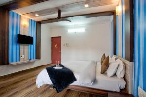 a bedroom with a large bed with white sheets and pillows at J0MAS 0utdoor 0Jost Stay in Baga