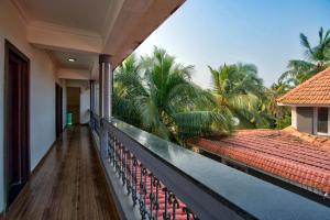 a balcony of a house with palm trees at J0MAS 0utdoor 0Jost Stay in Baga