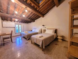 Un dormitorio con dos camas y una mesa dentro. en Le Mezzane, en Lucca 7 fotos más
