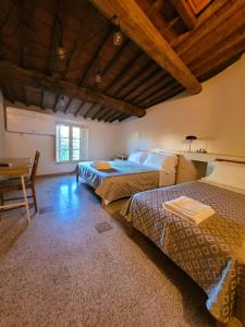 Un dormitorio con dos camas y una mesa y un escritorio. en Le Mezzane, en Lucca