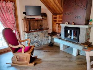 a living room with a fireplace and a chair at La Lune de Saint George in Hone