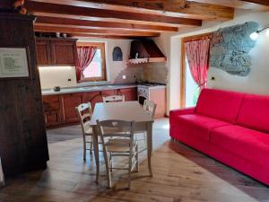 a living room with a red couch and a table at La Lune de Saint George in Hone