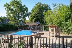 einen Spielplatz mit Rutsche und Schaukel in der Unterkunft Résidence de Leuvert in Cromvoirt