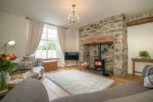 a living room with a large stone fireplace at Ficerdy in Llanwnda
