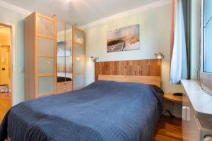 ein Schlafzimmer mit einem blauen Bett in einem Zimmer in der Unterkunft Ferienwohnung am Gespensterwald in Nienhagen