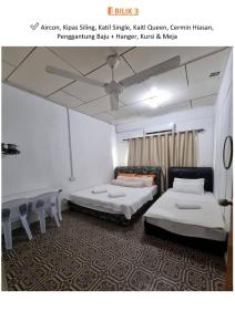 a room with two beds and chairs in it at Halwa Homestay in Semporna