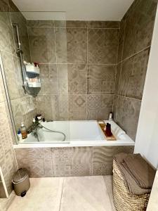 a bathroom with a bath tub and a sink at Malakoff - 3 pièces avec terrasse in Malakoff +8 photos