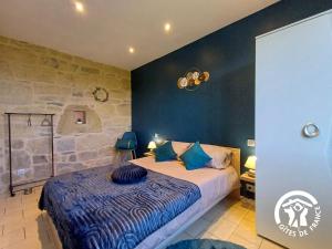 a bedroom with a king sized bed with blue sheets at L'Escapade in Gagnac