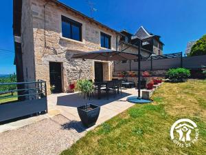 a patio with a table and an umbrella at L'Escapade in Gagnac