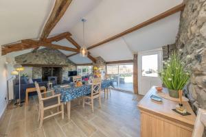 een eetkamer en een woonkamer met een stenen muur bij Bwthyn-Bennar in Dyffryn