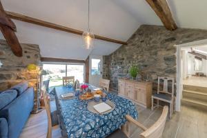 een woonkamer met een tafel en een blauwe bank bij Bwthyn-Bennar in Dyffryn