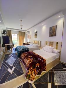 Un dormitorio con dos camas y una sala de estar. en فلورينزا الخمسين, en Hurghada