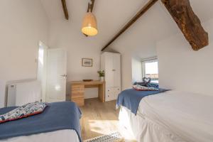 een slaapkamer op zolder met 2 bedden en een bureau bij Bwthyn-Bennar in Dyffryn