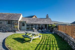 een picknicktafel in de tuin van een huis bij Bwthyn-Bennar in Dyffryn +20 foto's