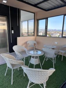a group of tables and chairs in a room with windows at Suite Sky and Sea in Flic-en-Flac