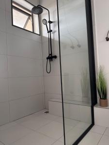 a shower in a bathroom with a glass door at Suite Sky and Sea in Flic-en-Flac