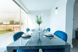 Un comedor con una mesa y sillas azules. en Stunning 4-Bed Beachfront Home Sea Views in Dymchurch, en Dymchurch