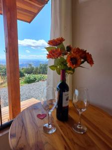 a table with two glasses and a bottle of wine at Chalés Ser Tão di Minas in Paraisópolis