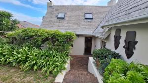 a house with statues on the side of it at The Cottage, Heide Avenue in Somerset West