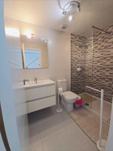 a bathroom with a sink and a toilet and a shower at Cozy, modern, two-level apartment in Orihuela Costa