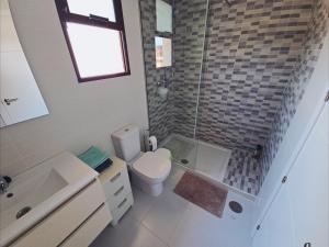 a bathroom with a toilet and a shower and a sink at Cozy, modern, two-level apartment in Orihuela Costa +10 photos