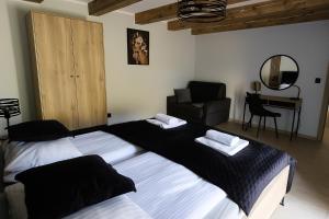 una camera da letto con due letti, una sedia e una scrivania di Apartamenty Rynek Szamotuły a Szamotuły