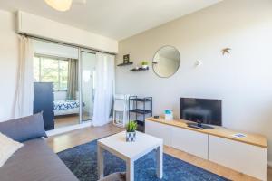 a living room with a couch and a tv at Le Senaya - Sanary in Sanary-sur-Mer
