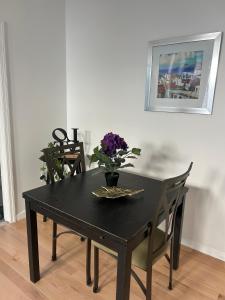 Una mesa negra con un jarrón de flores. en Cozy modern Bellerose, en Bellerose 3 fotos más