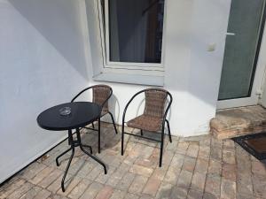 a table and two chairs sitting next to a window at Cozy apartment in Jeruzalė in Vilnius
