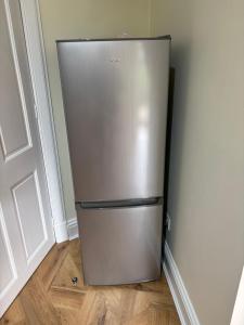 a stainless steel refrigerator in a corner of a room at Crescent Corner 44 Seamore Str Ground Floor Right in Largs