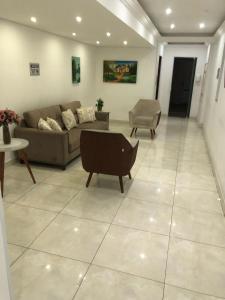 una sala de estar con un sofá y una silla en Apto até 6 pessoas -PG Aviação - 150mts e 1 vaga, en Praia Grande