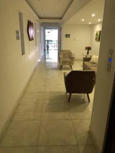 Un pasillo de una sala de estar con un sofá y sillas. en Apto até 6 pessoas -PG Aviação - 150mts e 1 vaga, en Praia Grande