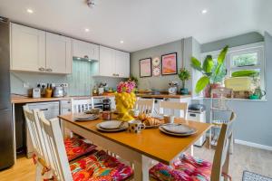 a kitchen with a wooden table with chairs and a dining room at 3 Bed in Wotton-under-Edge oc-l33488 in Wotton under Edge